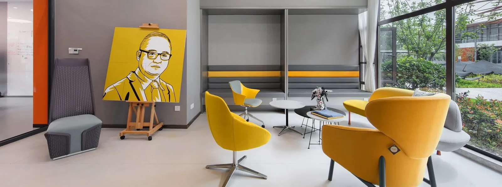 Área lounge corporativa con butacas amarillas y mesas Kano